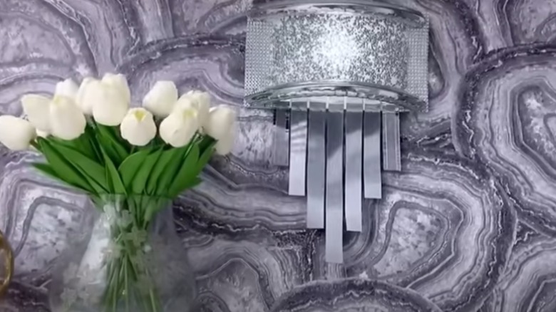 Silver wall sconce on textured wall