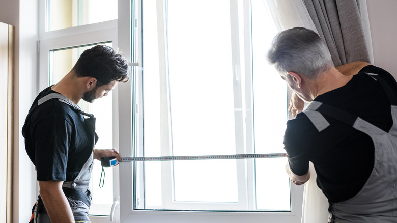 two men measuring window