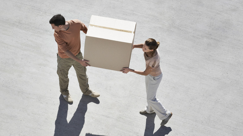 two people carrying box