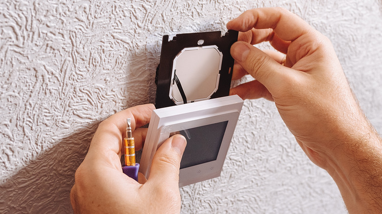 man installing a new thermostat