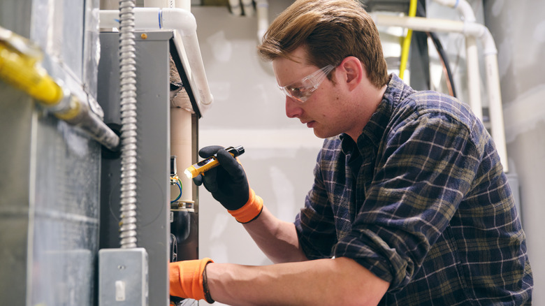 man repairing a furnace