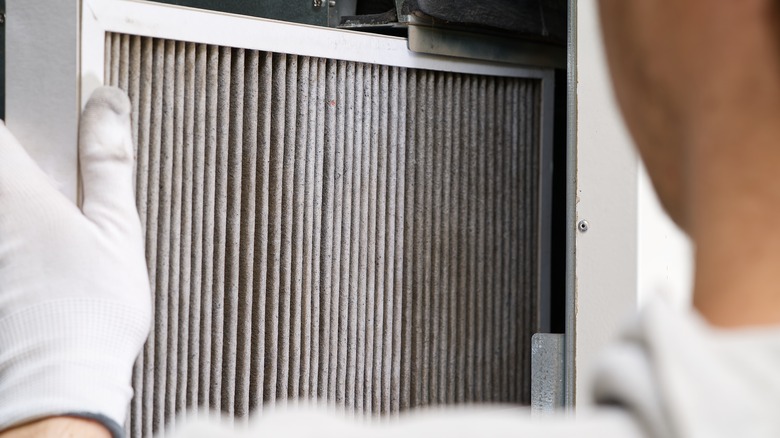 person changing furnace filter