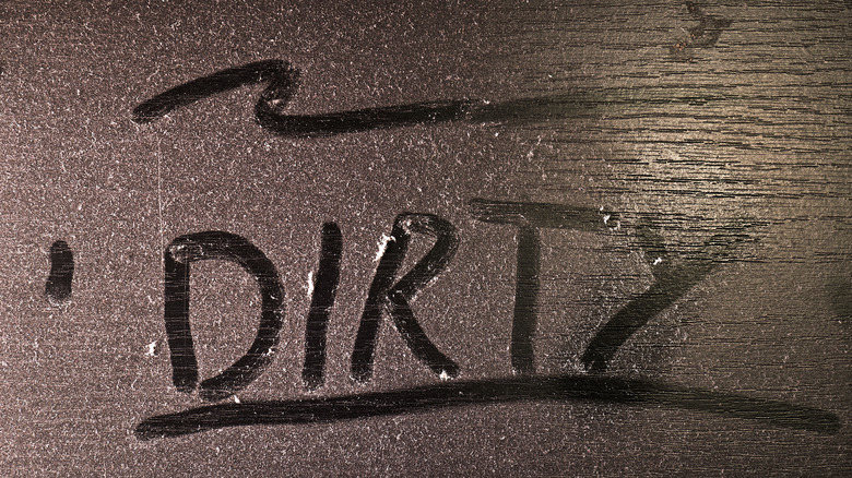 "Dirty" written in dust