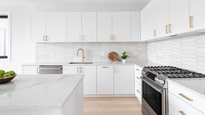 A white kitchen with ceramic backsplash tiles.