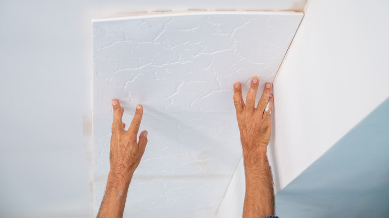 Person installing ceiling tile