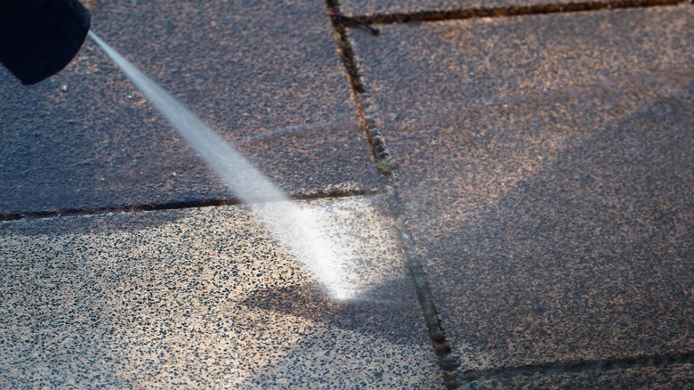 Close-up pressure washer on pavers