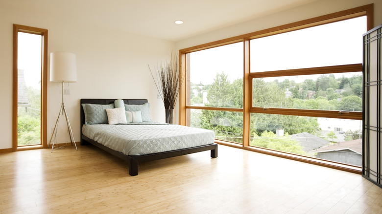 Bedroom with bamboo flooring and a large window