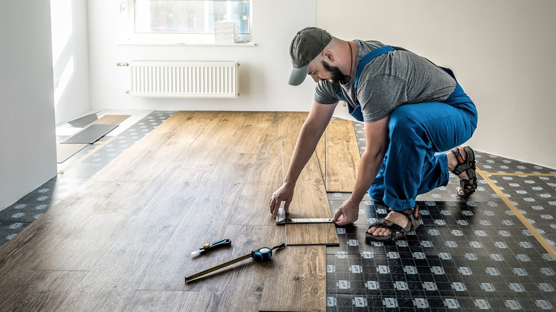 carpenter installing vinyl plank flooring