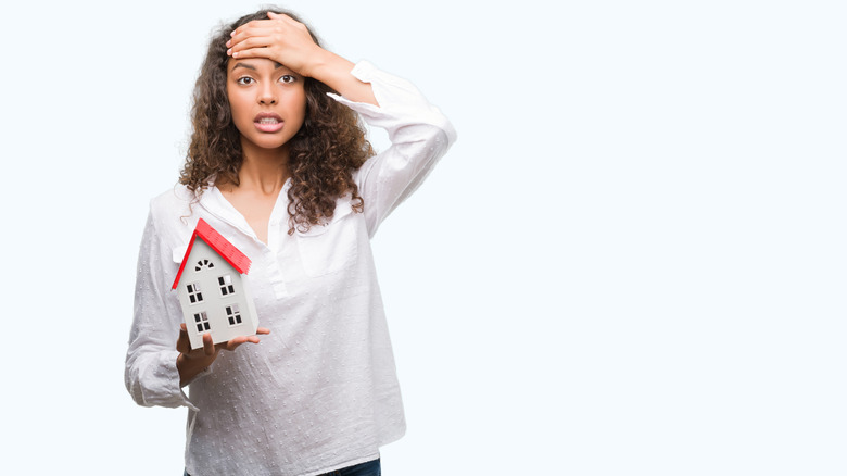 stressed woman holding house