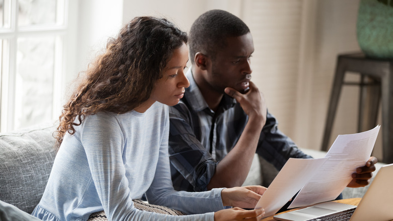 stressed couple reading contracts