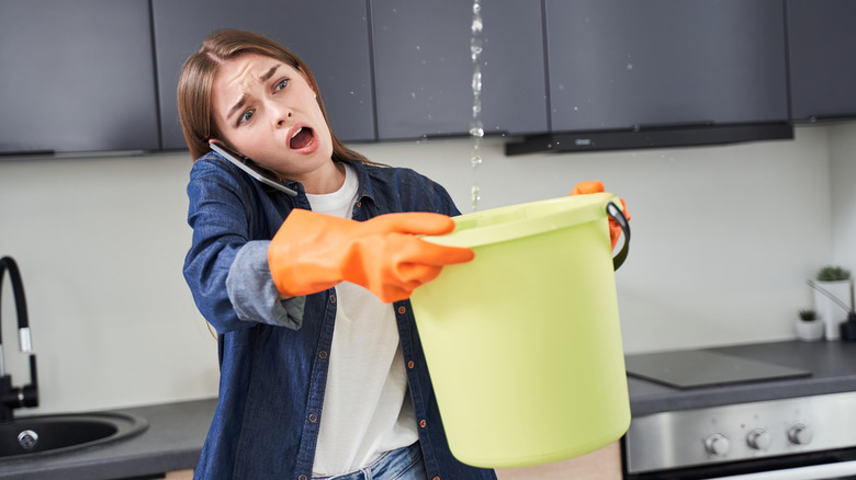 woman holding bucket with leak