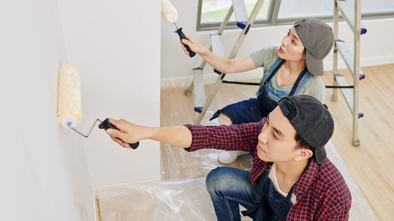 couple painting walls in new home