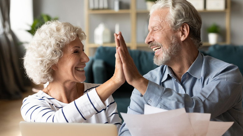 older couple high fiving 