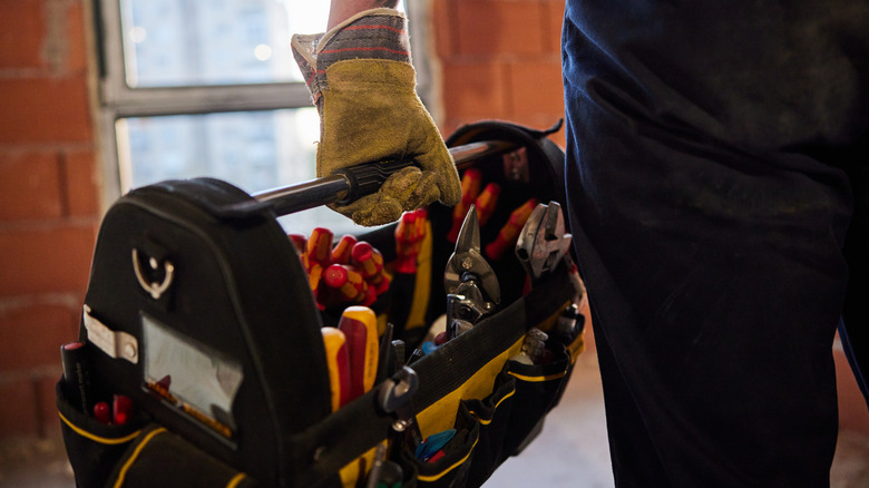 Construction worker carrying toolbox