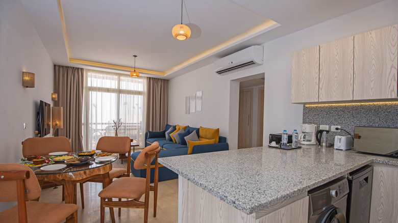 An apartment with a full wall of curtains obscuring a sliding glass door