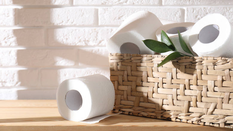 Toilet paper rolls in a basket on a shelf