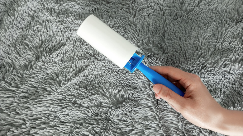 hand holding blue lint roller 