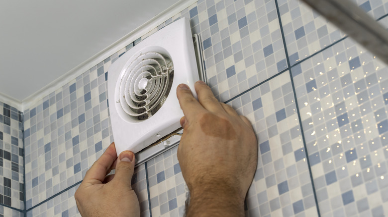 A bathroom fan being removed