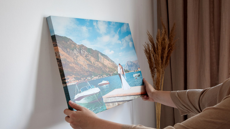 Woman holding canvas on wall