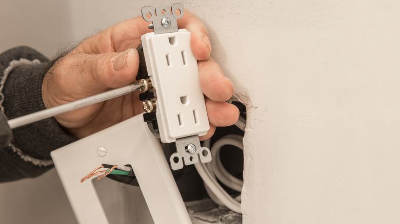 Person repairing electrical outlet