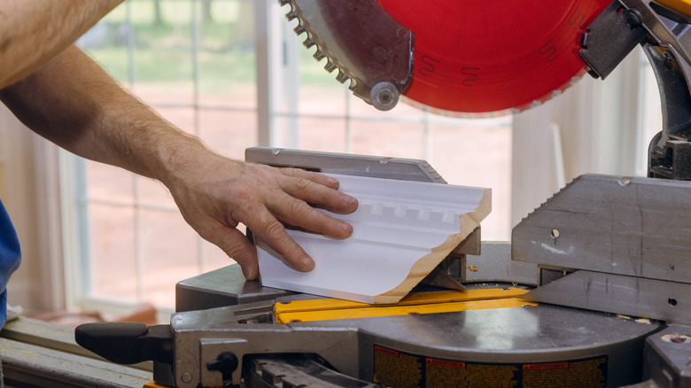 Hands cutting crown molding