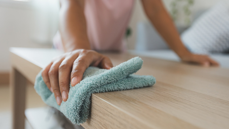 Person wiping spill on table 