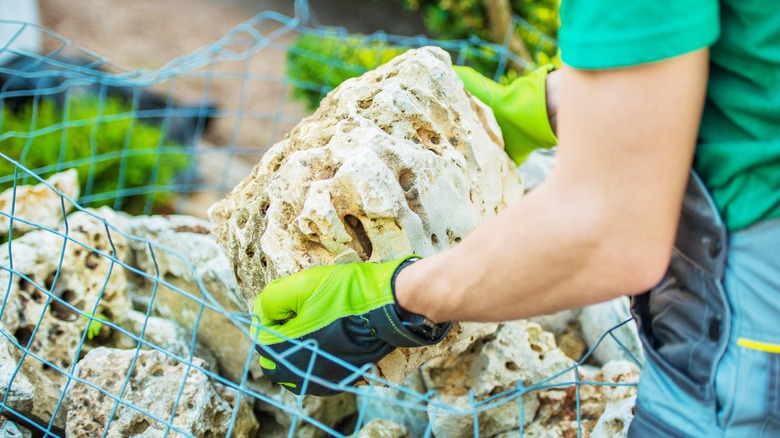 Hands holding large rock