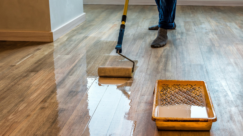 Applying sealer to a hardwood floor with a roller