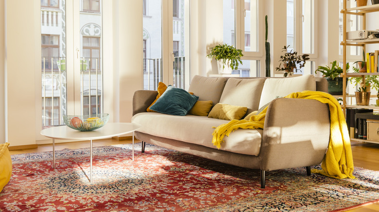 Highly patterned rug over hardwood floors under a couch