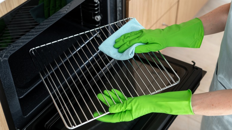 person cleaning oven racks