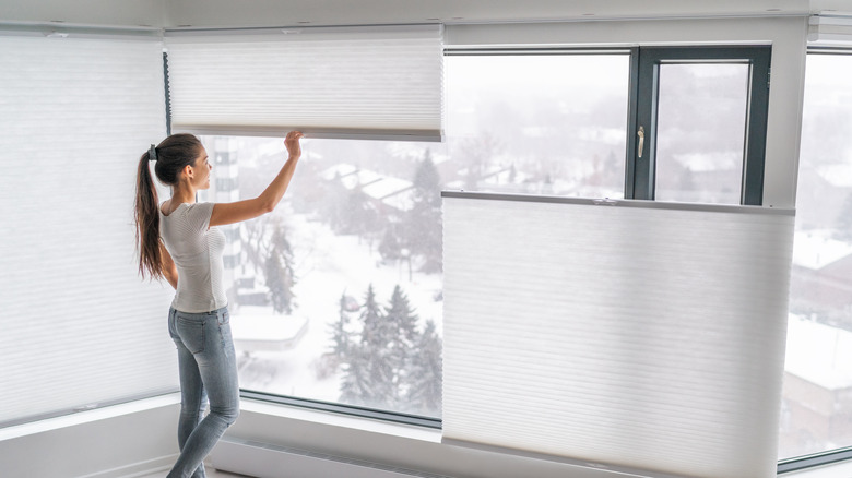 Woman fixing top-down blinds