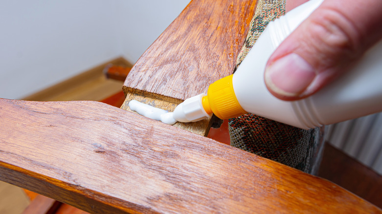 Person gluing pieces of wood.