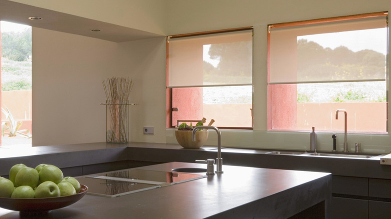 Stylish kitchen with large white roller blinds