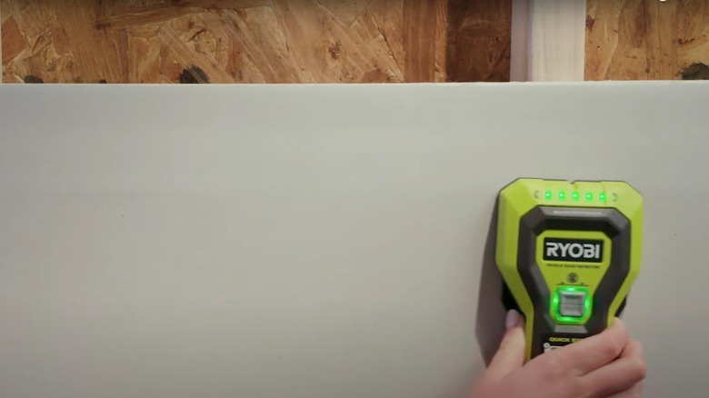 Woman using Ryobi stud finder