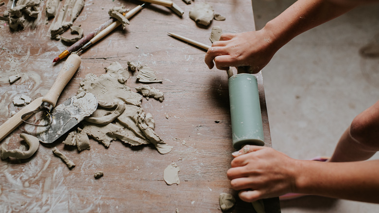 person rolling out clay