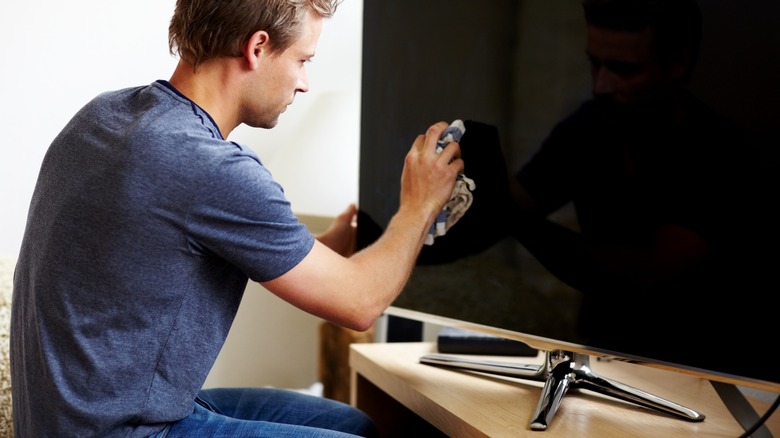 Person cleaning TV screen