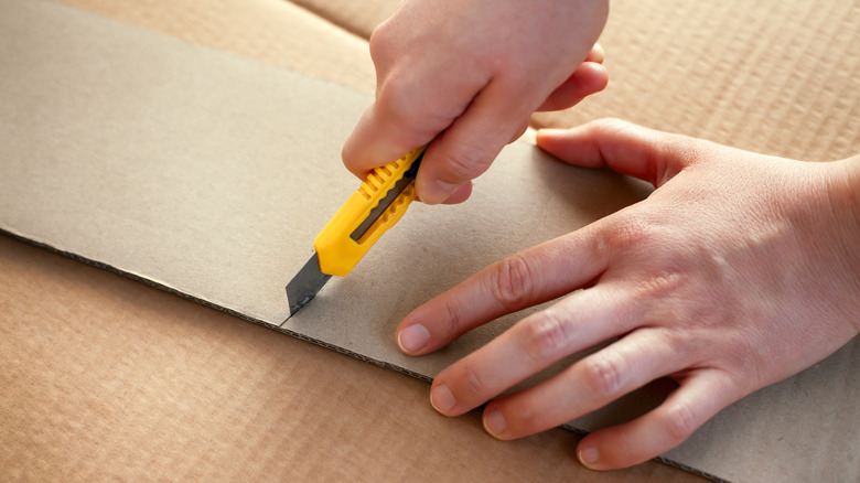 person cutting cardboard