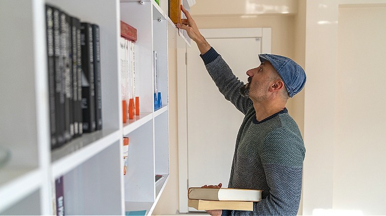 Person organizing bookshelf