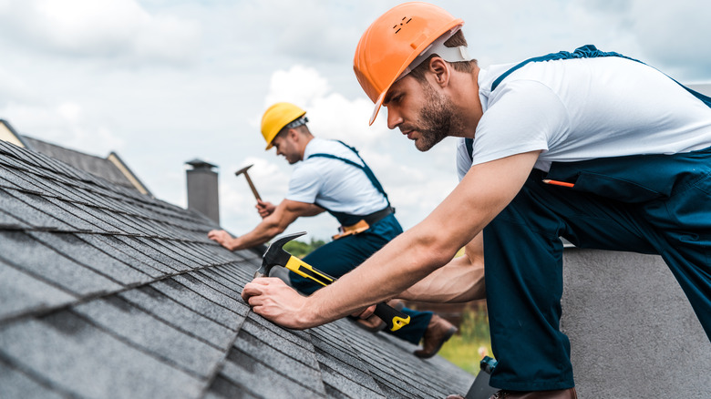 Two men repairing a roof