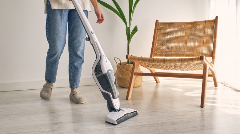 Woman vacuums laminate flooring