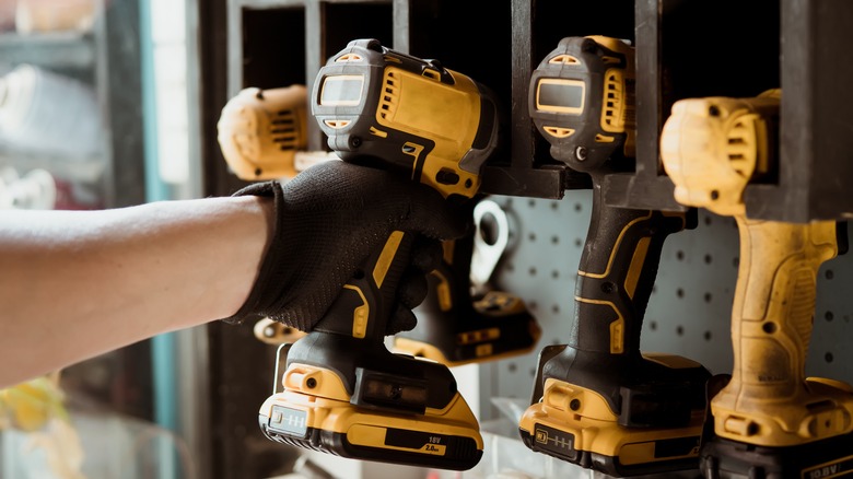 person grabbing electric drill garage