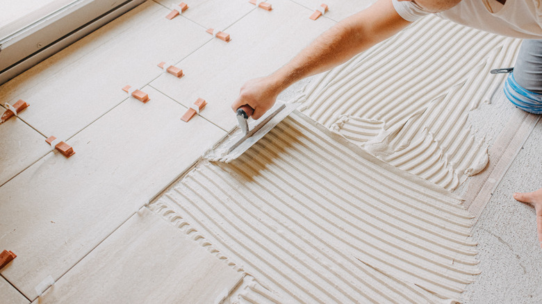 Man tiling floor