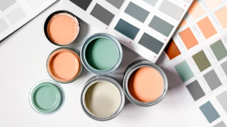 Peach and green paint in cans above color swatches