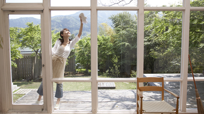 Woman polishing window with cloth