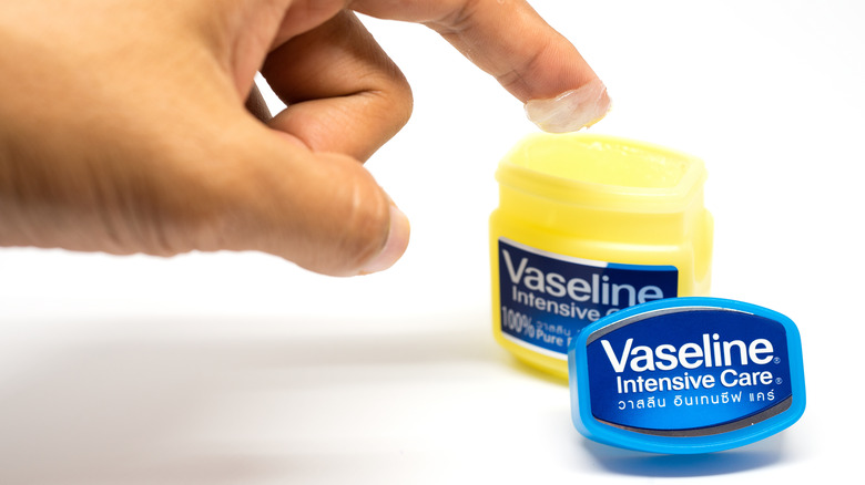 finger dipping into petroleum jelly