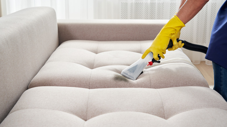 person vacuuming mark on couch