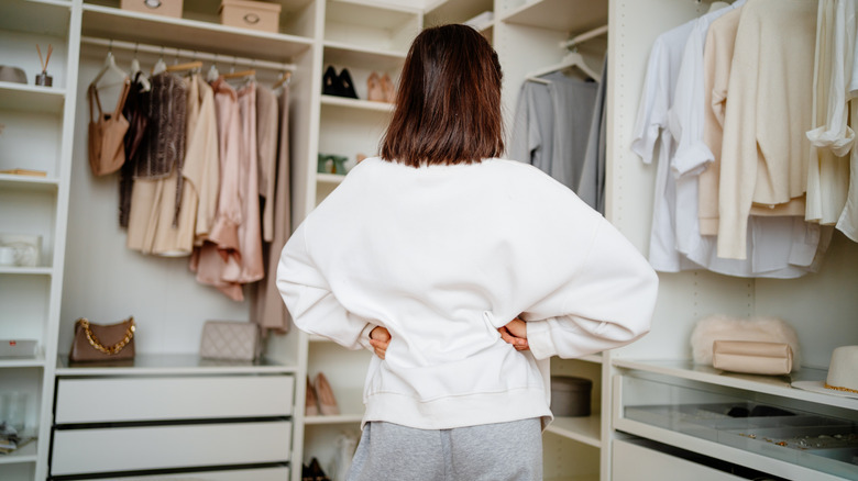 Woman trying to organize walk-in closet