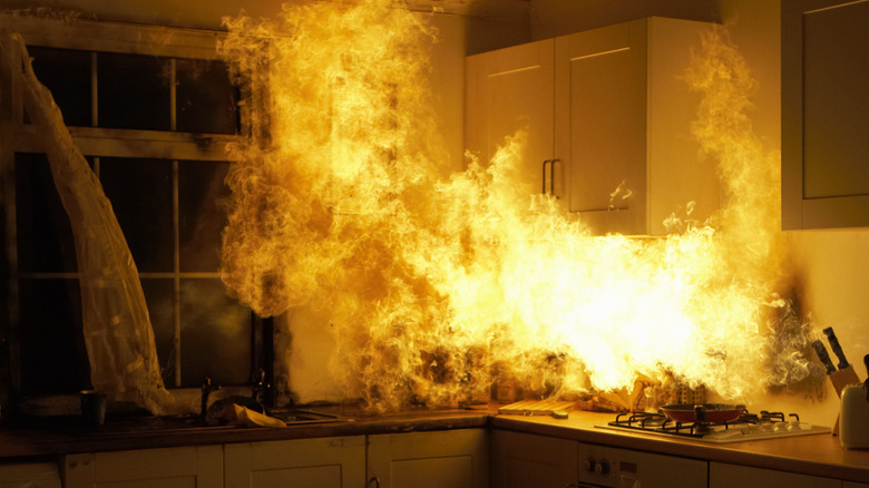 Flames burn the cabinets and countertop items in a kitchen