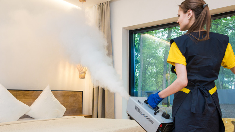 Woman spraying steam over bed