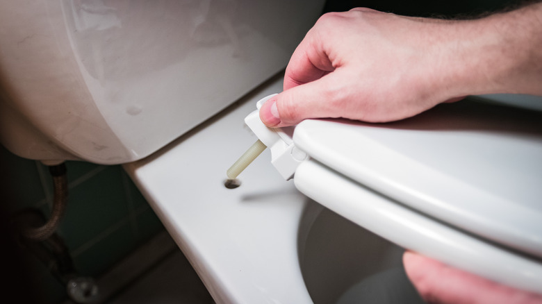 man installing toilet seat